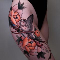 Damski tatuaż na udzie ptaszek