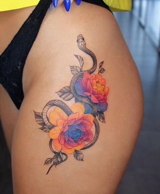 Tatuaż wąż i kolorowe kwiaty dla kobiety 