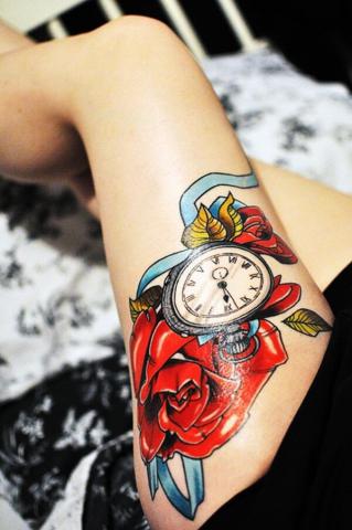 Zegar i kwiaty na udzie tatuaż