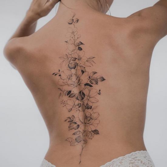 Kwiaty wzdłuż kręgosłupa tatuaż damski